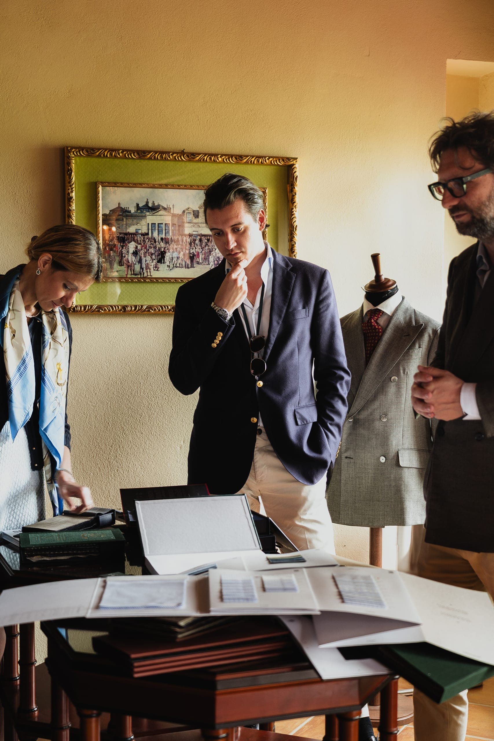 Men gathered around a table covered in papers and plans, going over details