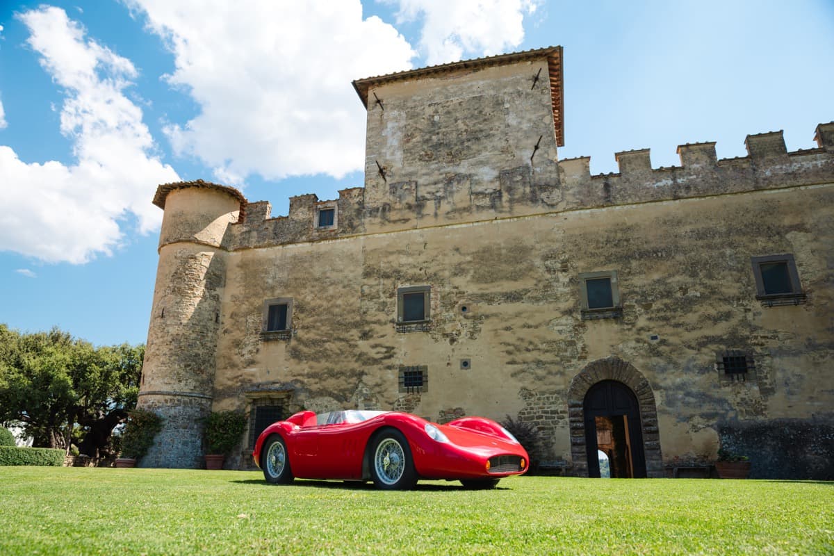 La facciata merlata del Castello della Paneretta con una barchetta rossa d'epoca sul prato