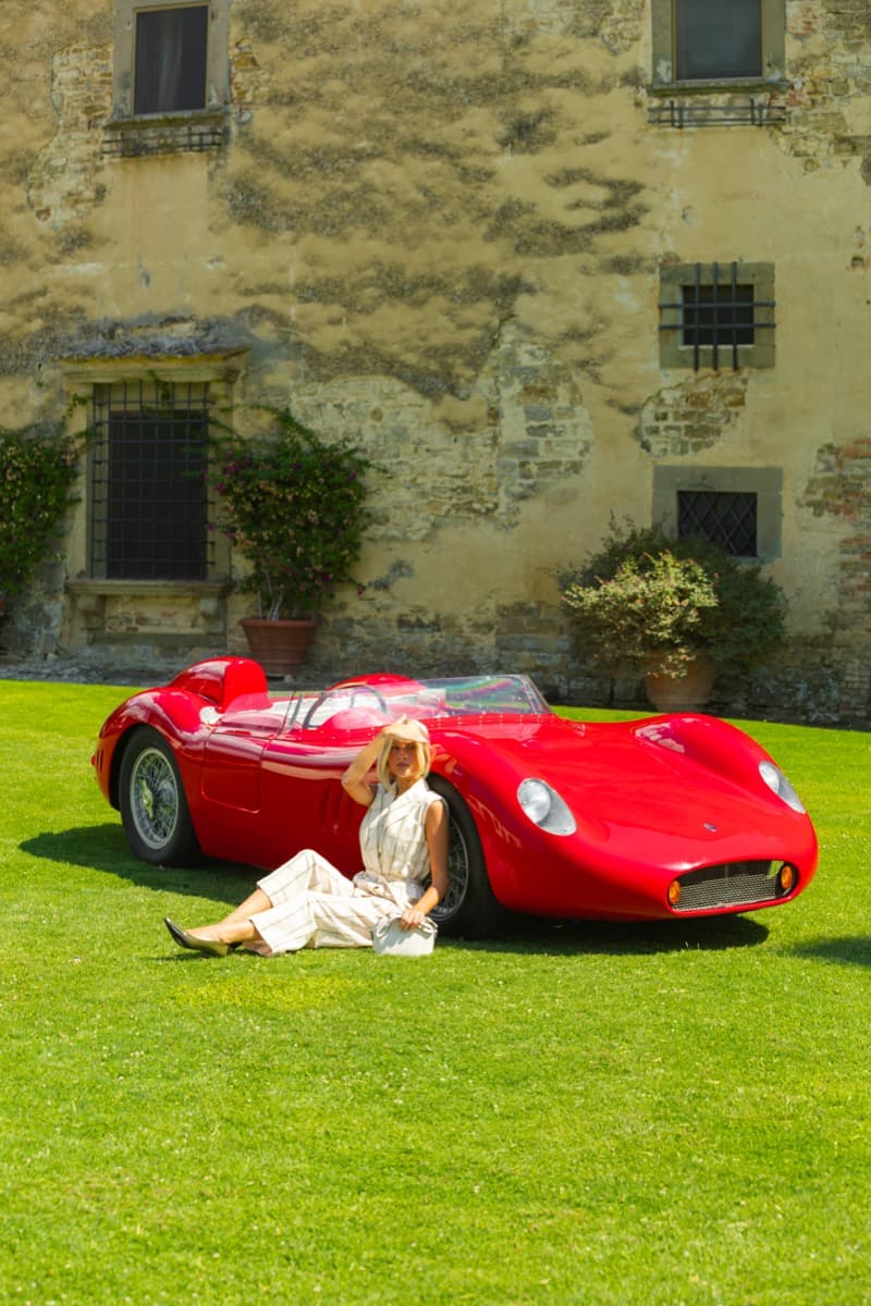 Ospite accanto alla vettura d'epoca lungo il muro con le rose rampicanti