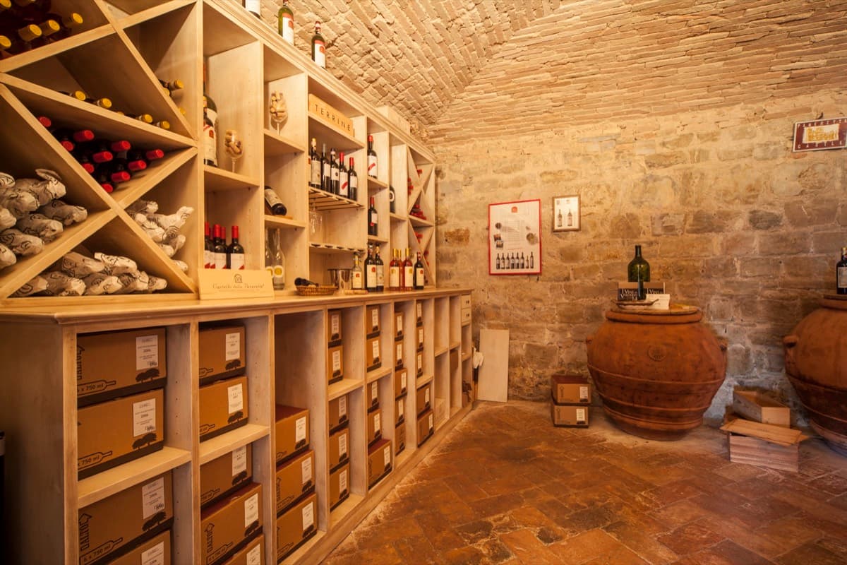 Enoteca del Castello della Paneretta con gli scaffali di bottiglie e gli orci in terracotta